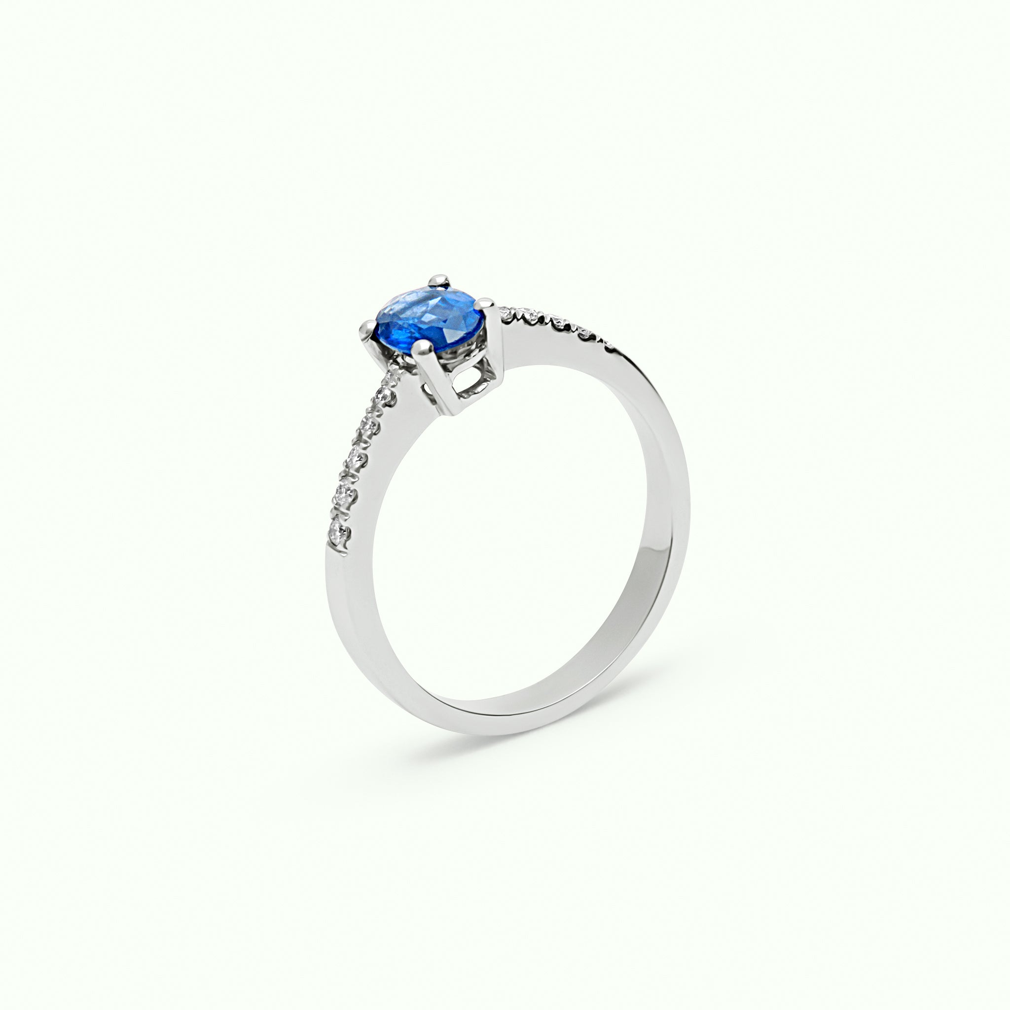 Anillo solitario de oro blanco 18kt con zafiro azul talla oval y diamantes talla brillante en el brazo - ETERNO