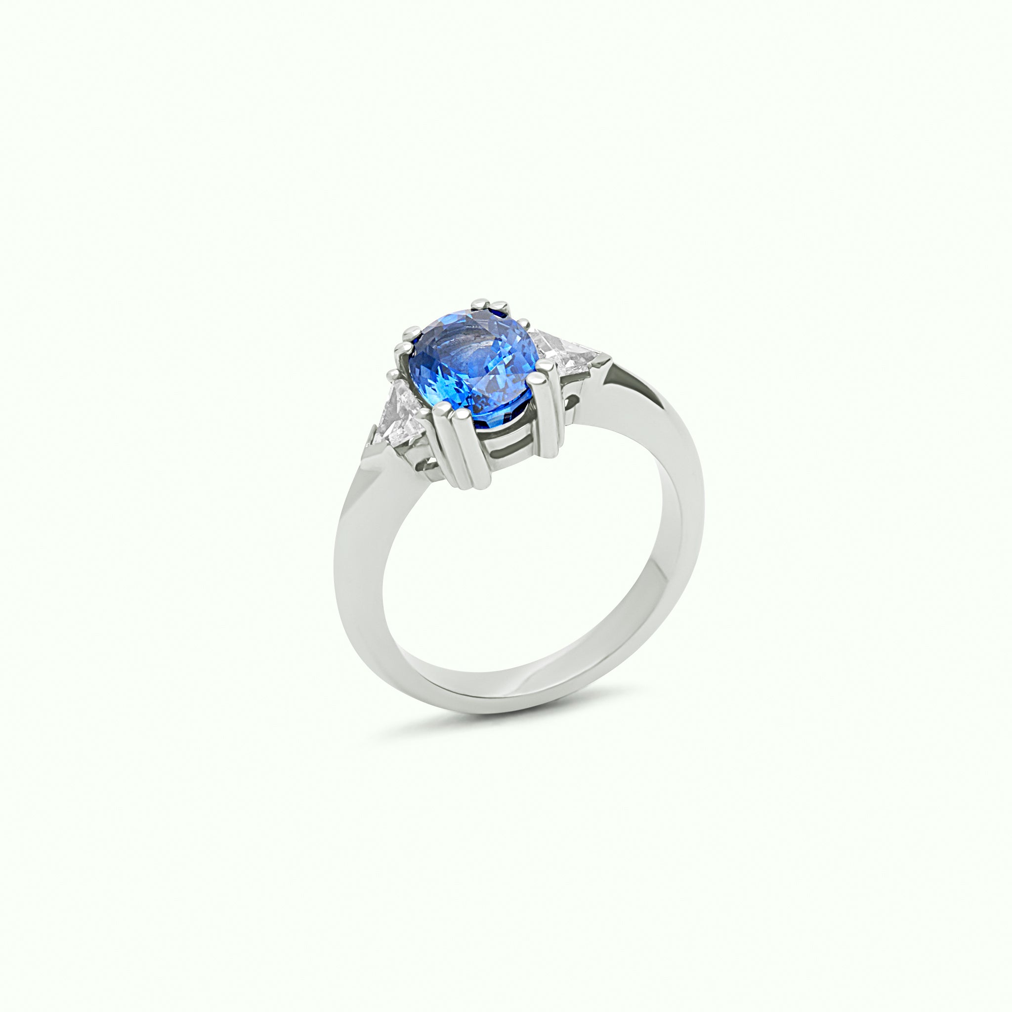 Anillo Tresillo de oro blanco 18kt con zafiro azul natural talla oval de 2,47ct central y dos diamantes talla trillante de 0,40ct - REAL