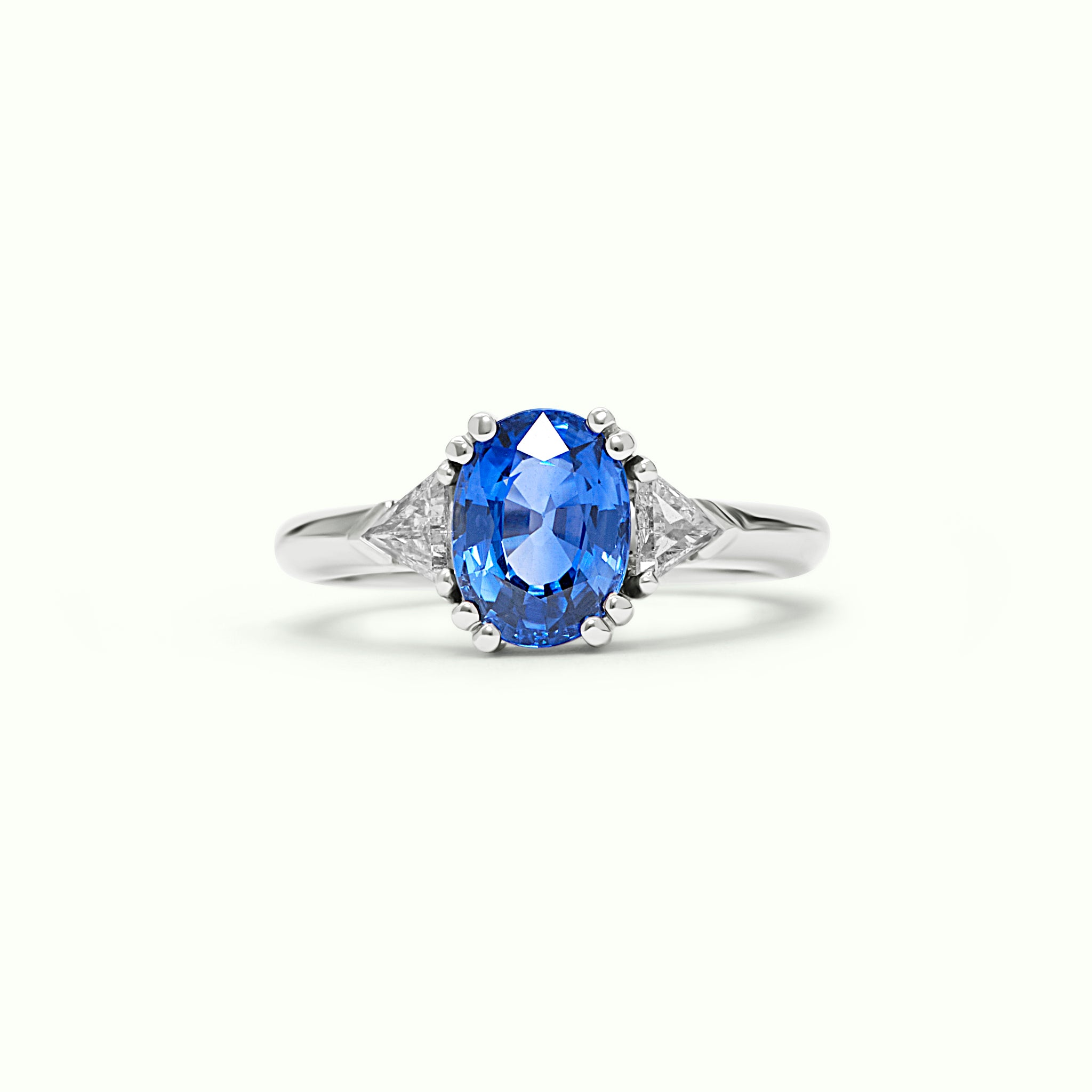 Anillo Tresillo de oro blanco 18kt con zafiro azul natural talla oval de 2,47ct central y dos diamantes talla trillante de 0,40ct - REAL