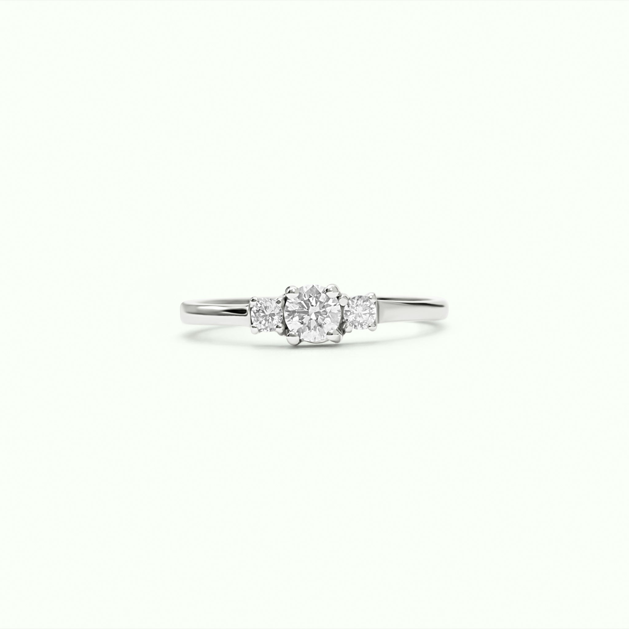 Anillo solitario con diamante central y dos diamantes laterales montados con 4 grapas en oro blanco de 18K – Destino