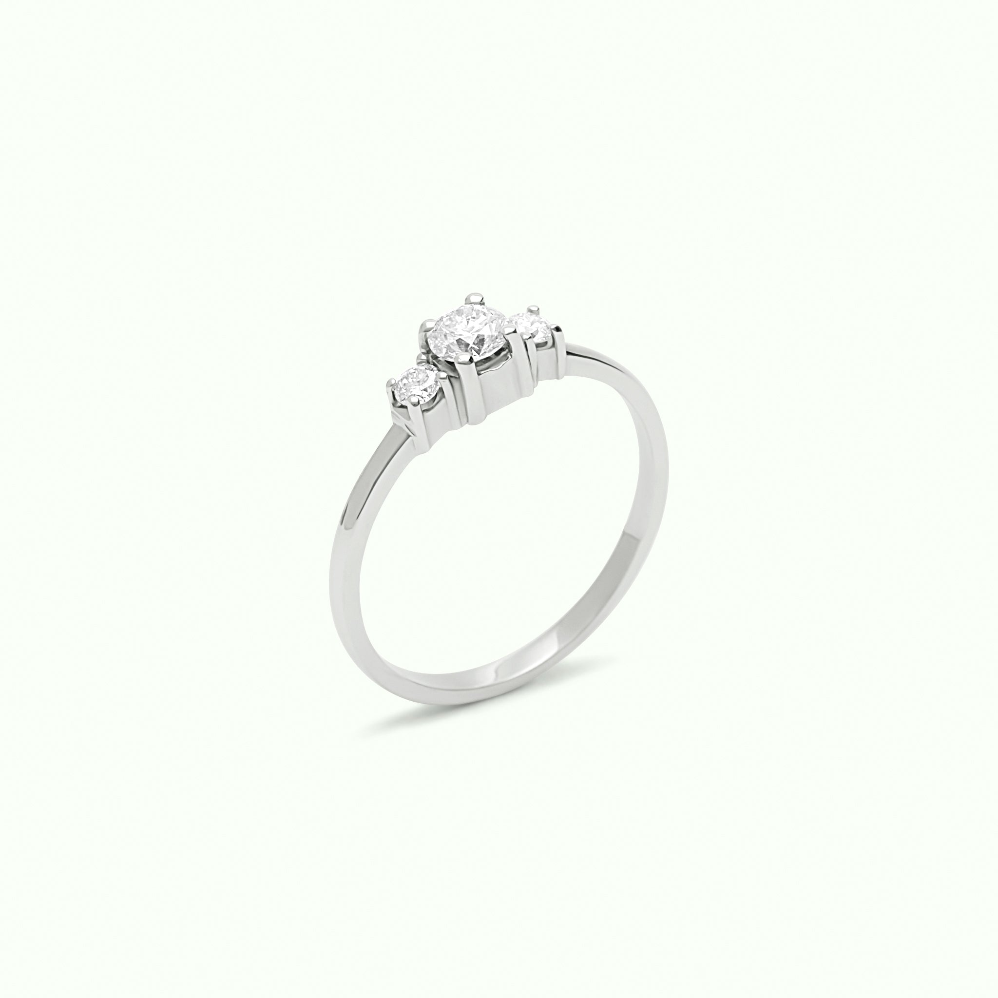 Anillo solitario con diamante central y dos diamantes laterales montados con 4 grapas en oro blanco de 18K – Destino